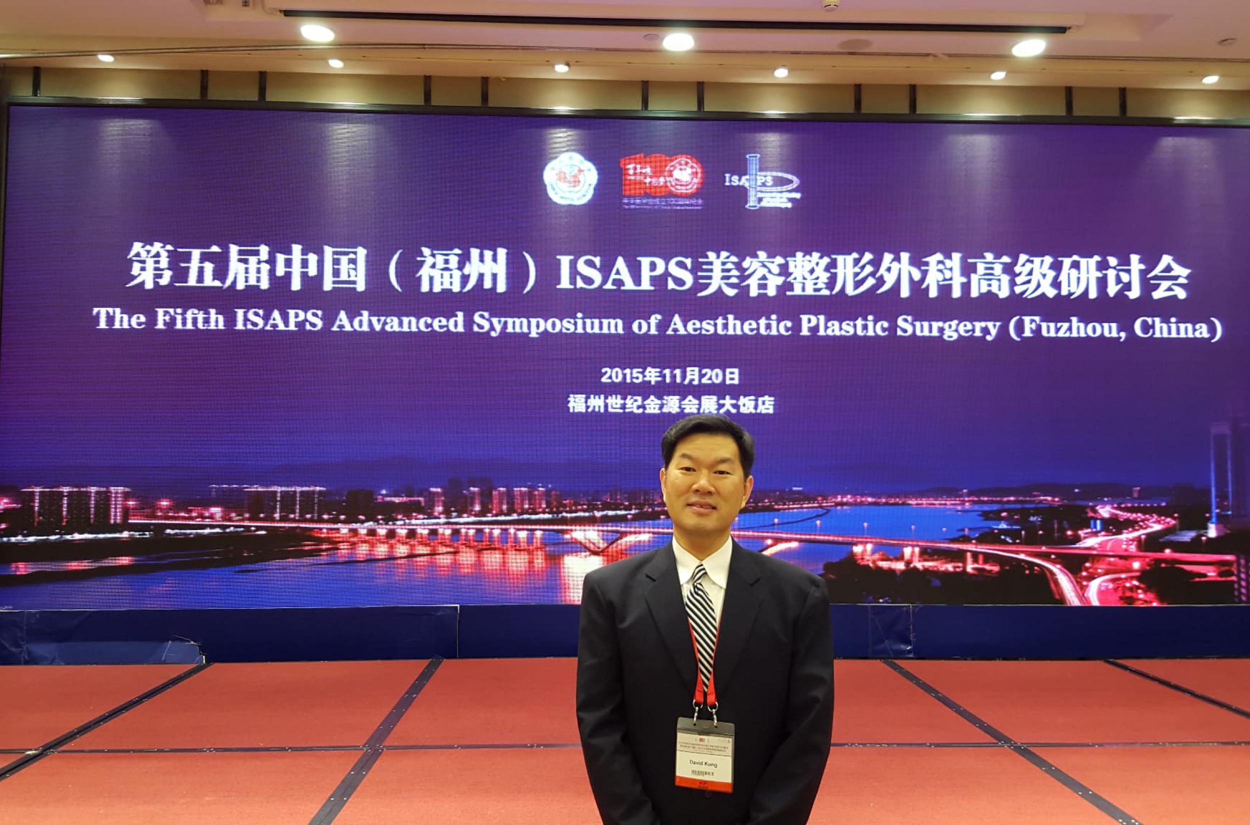 Dr. Kung in front of a large screen